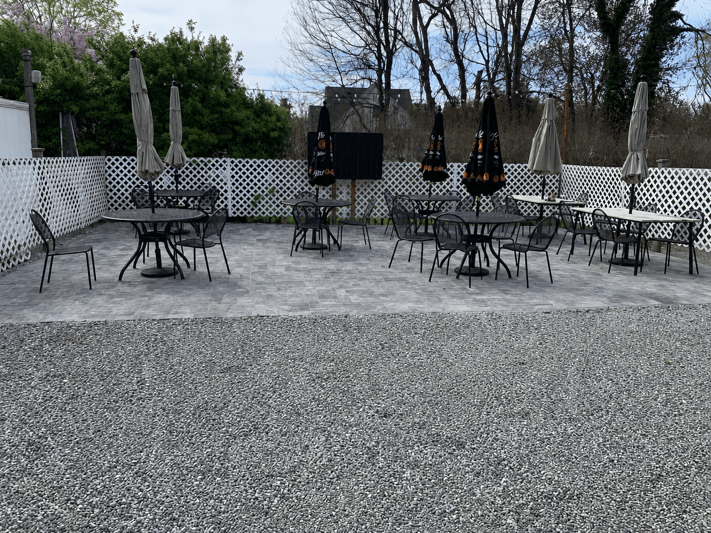 Tempus crew mid-install laying gray paver bricks on a compacted sand base
